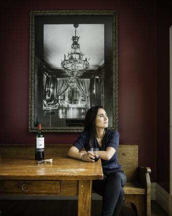 Laura Catena sits at a table with a glass of wine